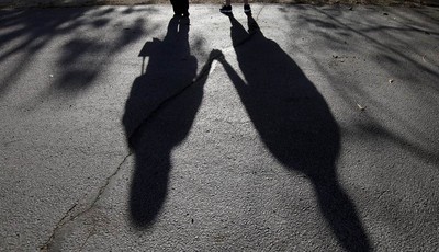 
              This Sept. 20, 2012 photo shows the shadows of a young woman from Rockford, Ill., left, with her husband. When her doctor said a medical condition made her unplanned pregnancy too risky